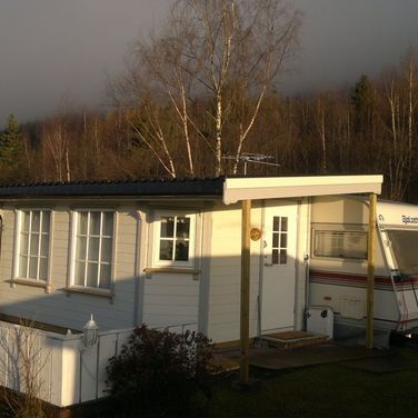 Hvitt spikertelt med campingvogn